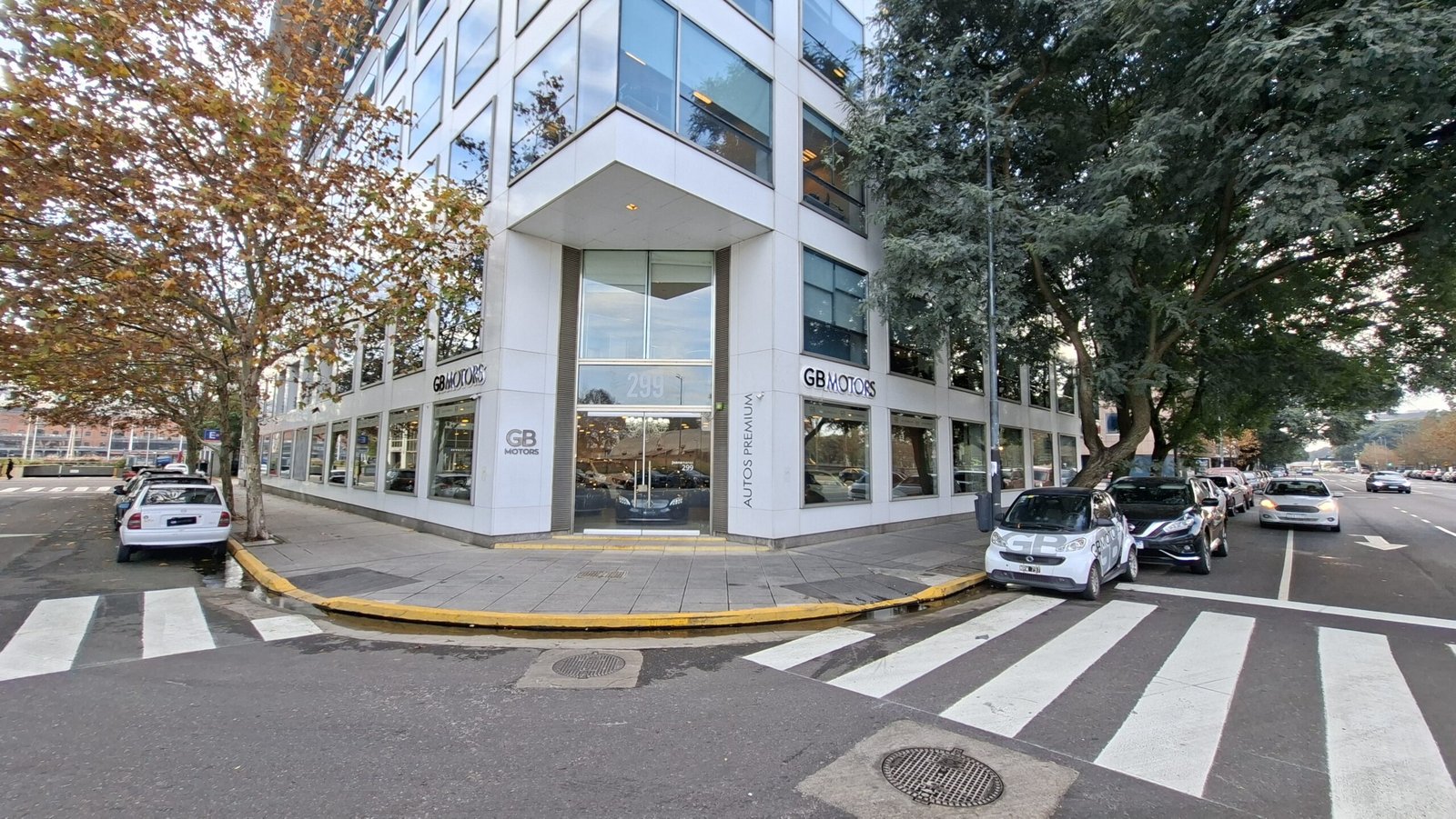 Esquina vidriada del showroom de GB Motors vista desde la senda peatonal